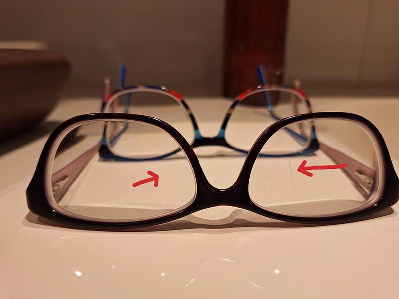 Kaum zu sehen, aber störend: Die beiden Kratzer in der Brille. Dahinter die neue bunte Brille mit komplettem Weichmacher.