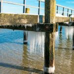 Eiszapfen unter einem alten Steg in Travemünde