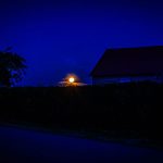 Der Erdbeermond hinter dem Häusern in unserem Dorf.