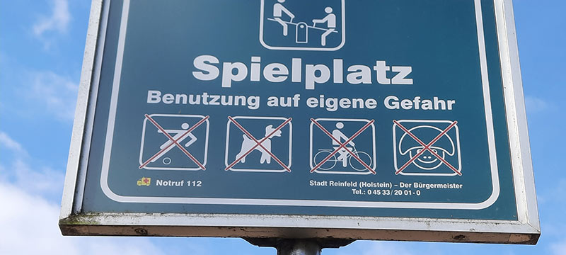 Spielplatz-Schild mit Piktogrammen, was alles verboten ist.