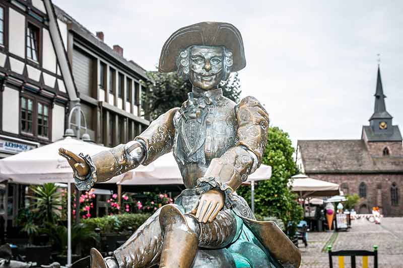 Mitten in der Stadt reitet Baron von Münchhausen auf seiner Kanonenkugel.